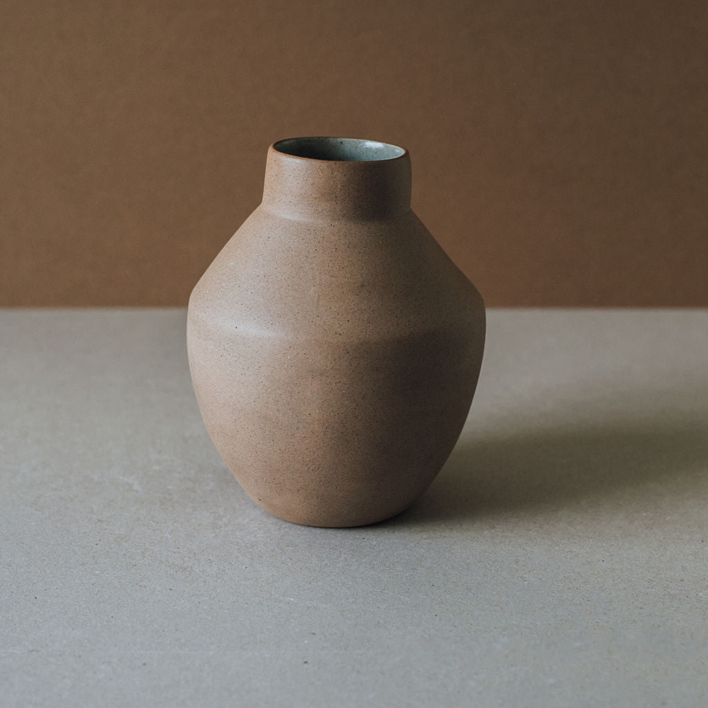 Tall hand-thrown clay vase in raw earth tones, modern Mexican home decor