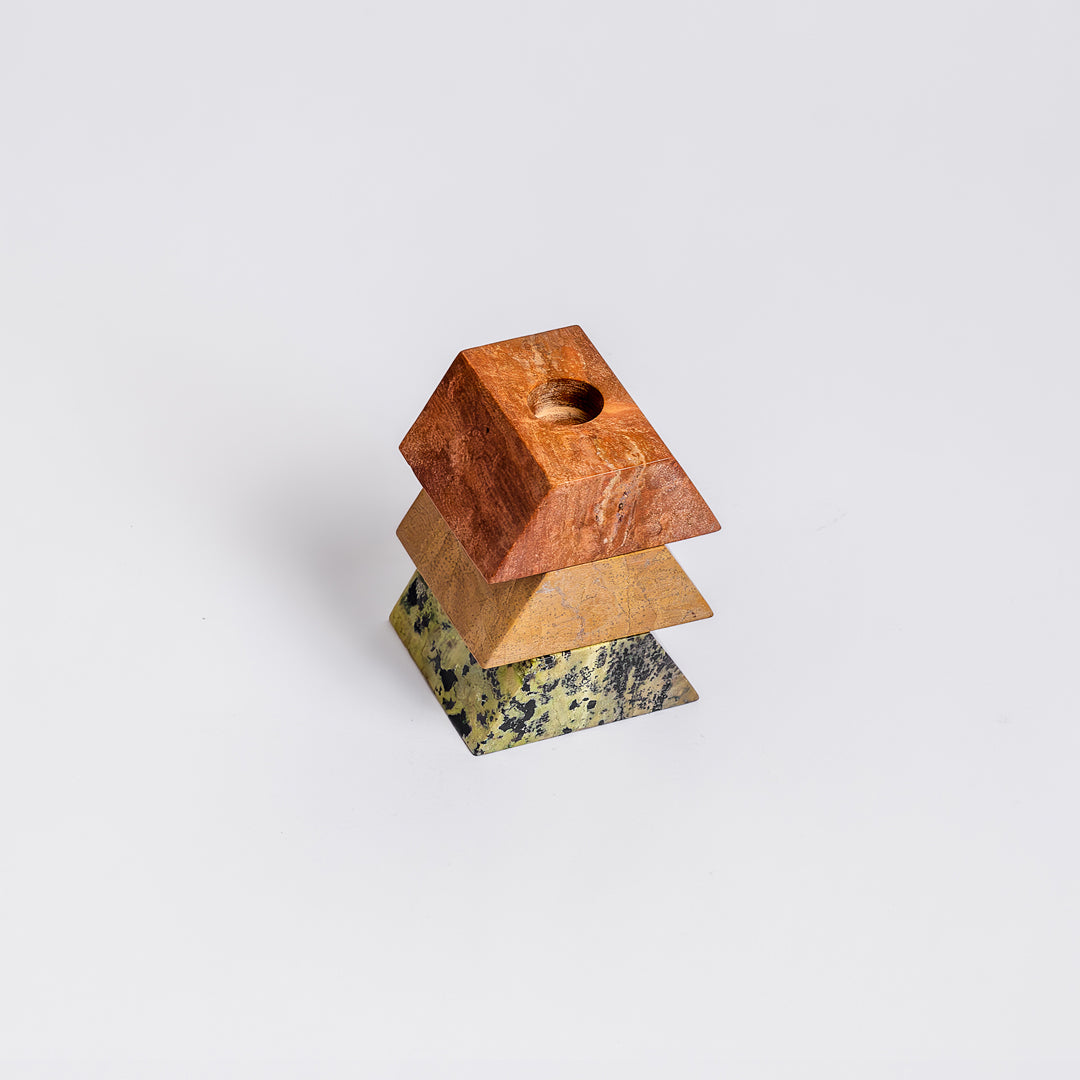 Geometric colorful stone marble pyramid candlestick holder with a white background